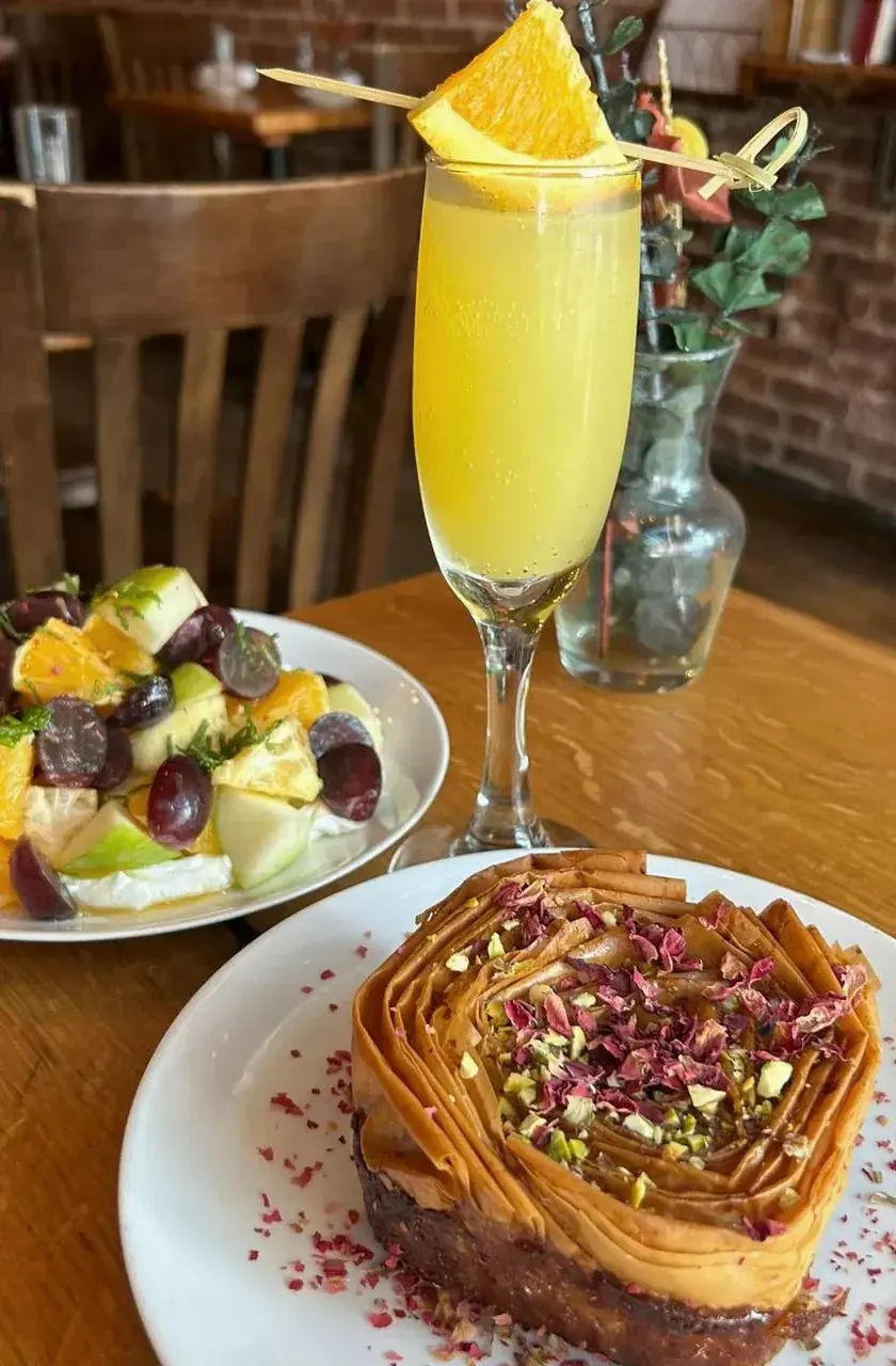 A mimosa with a phyllo bun and fruit at brunch